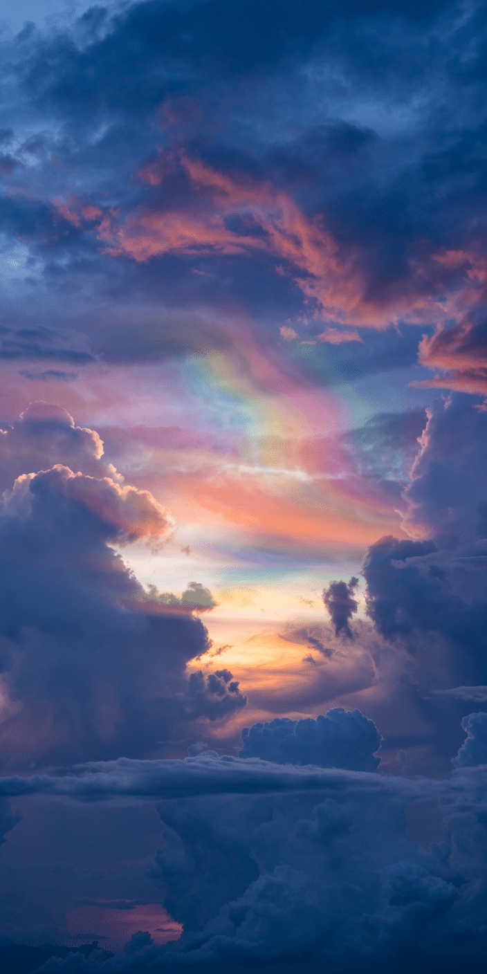 This stunning wallpaper features rare iridescent clouds glowing in pastel shades of pink, green, and violet against a soft sunset sky. The surreal light display creates a dreamy, magical atmosphere. Perfect for fans of clouds wallpaper and sky aesthetic, this unique moment makes for an unforgettable background.